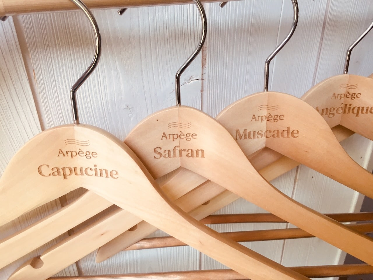 Cintres en bois avec noms gravés.
